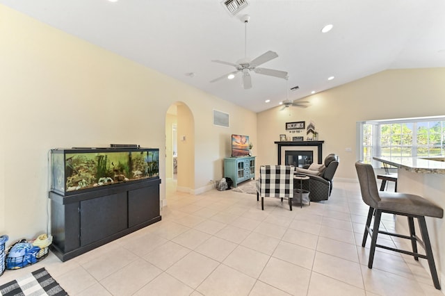 living room featuring ceiling fan, lofted ceiling, and light tile patterned flooring