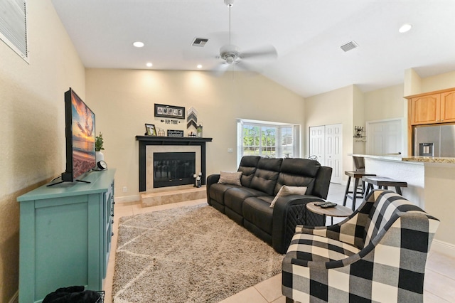 living room featuring ceiling fan, light tile patterned floors, and vaulted ceiling