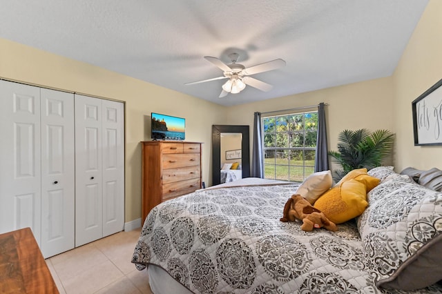 tiled bedroom with ceiling fan, a textured ceiling, and a closet