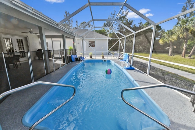 view of swimming pool featuring french doors, a patio area, ceiling fan, and a lanai