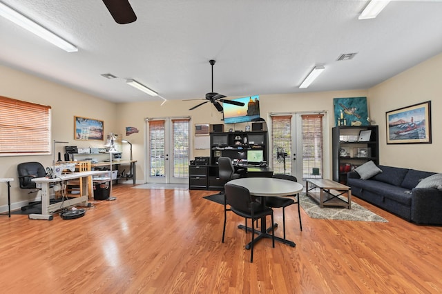 office area with a textured ceiling, light hardwood / wood-style flooring, and french doors