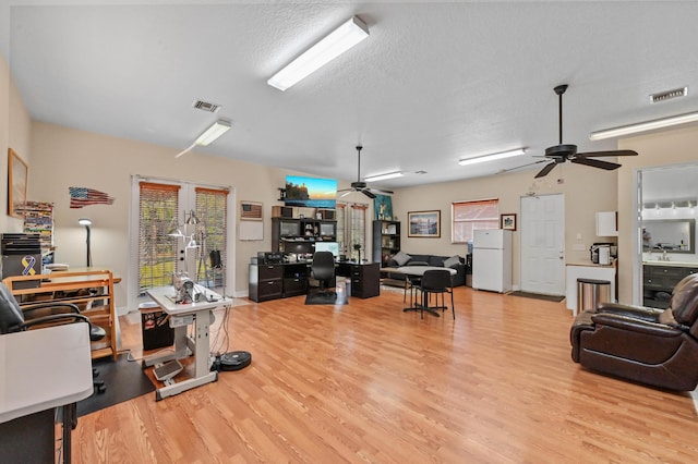 office with a textured ceiling, light hardwood / wood-style floors, and ceiling fan