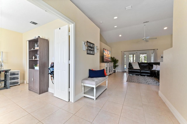 hallway with light tile patterned flooring, lofted ceiling, and french doors