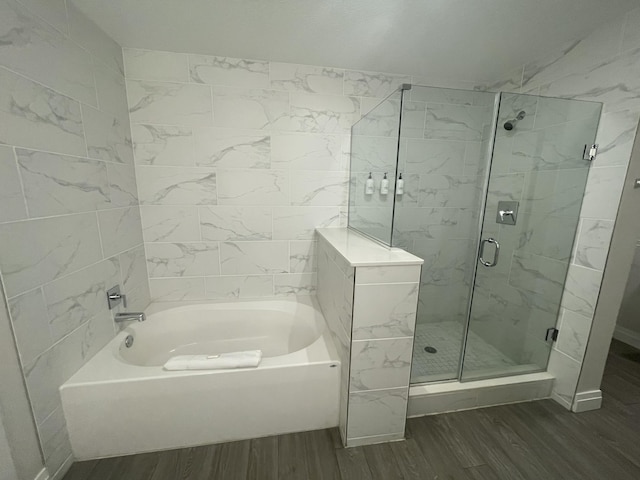 bathroom with wood-type flooring and shower with separate bathtub