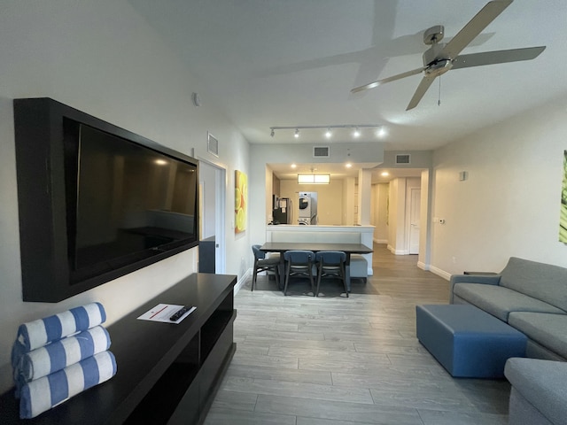 living room featuring light hardwood / wood-style flooring and ceiling fan