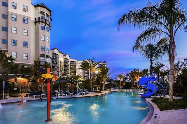 pool at dusk with a water slide