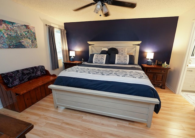 bedroom featuring connected bathroom, a textured ceiling, light hardwood / wood-style floors, and ceiling fan