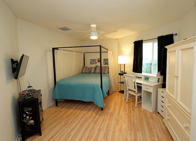 bedroom featuring a textured ceiling, light wood-type flooring, visible vents, and a ceiling fan