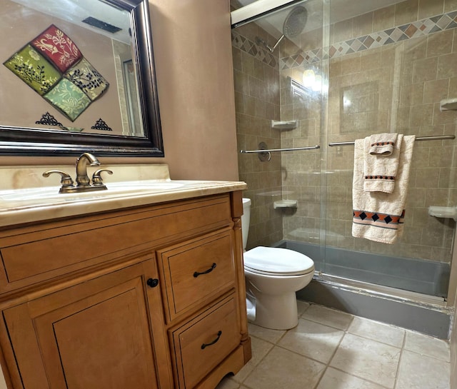 bathroom with toilet, tile patterned floors, tiled shower, and vanity