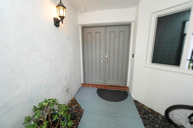 view of exterior entry featuring stucco siding