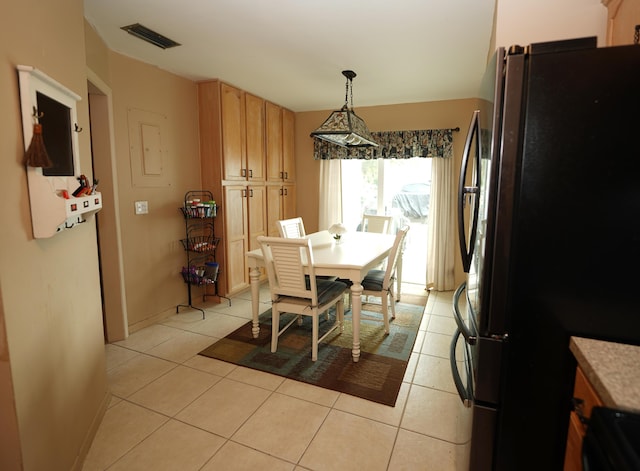 dining room featuring light tile patterned flooring, visible vents, and baseboards