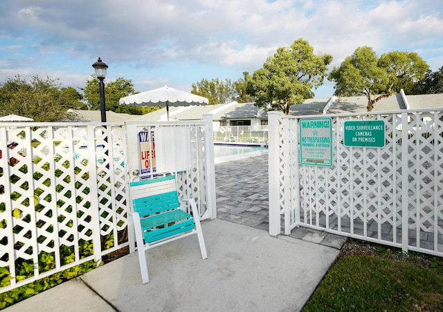 view of gate featuring a community pool