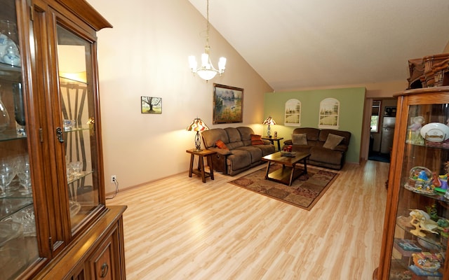 living room with a chandelier, high vaulted ceiling, and wood finished floors