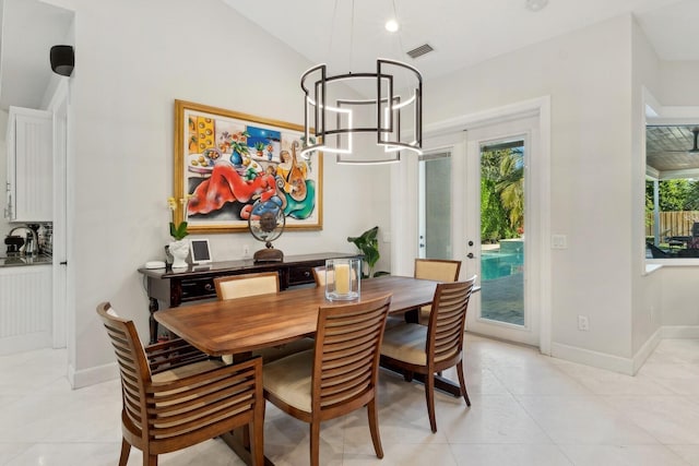 dining room featuring french doors, an inviting chandelier, and light tile patterned flooring