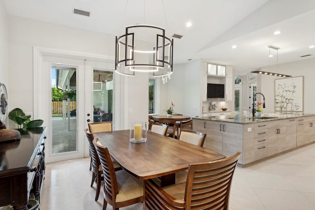 tiled dining room with a notable chandelier, french doors, vaulted ceiling, and sink