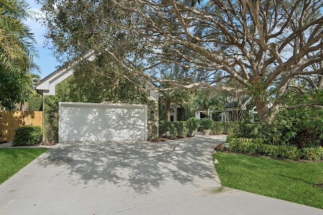 obstructed view of property featuring a front lawn and a garage