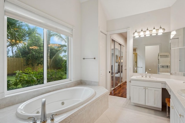 bathroom with vanity, tile patterned flooring, and a relaxing tiled tub