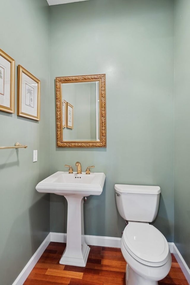 bathroom with toilet and hardwood / wood-style flooring