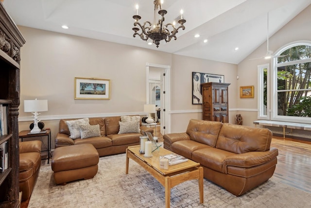 living room featuring vaulted ceiling, light hardwood / wood-style floors, and a notable chandelier