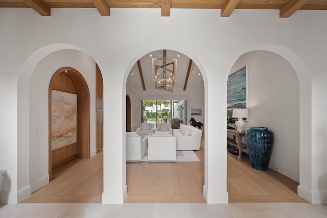 corridor with beam ceiling, light tile patterned floors, and a chandelier