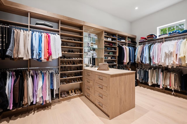 walk in closet with light hardwood / wood-style flooring