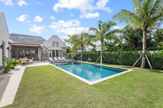 view of swimming pool with a yard and a patio