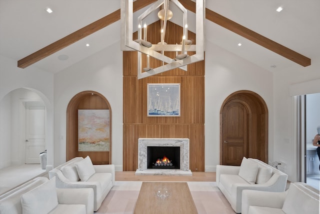 living room with beamed ceiling, a fireplace, and high vaulted ceiling