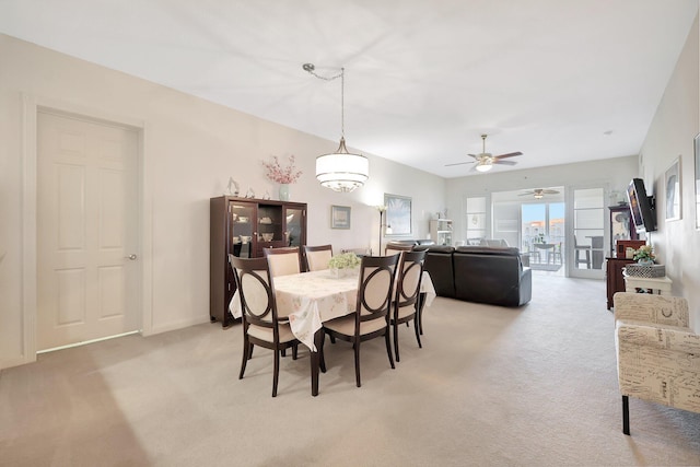 dining area with light carpet and ceiling fan