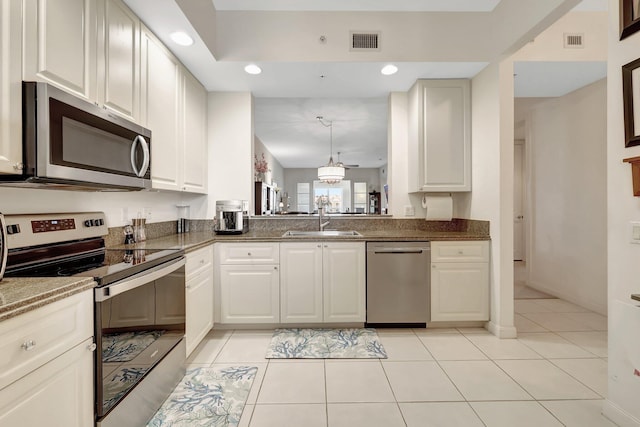 1 Harbour Isle Dr E Unit Ph2, Hutchinson Island, FL 34949 - kitchen with appliances with stainless steel finishes, a sink, recessed lighting, light tile patterned flooring, and dark stone countertops