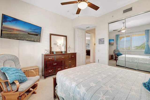 bedroom featuring ceiling fan, light colored carpet, and a closet