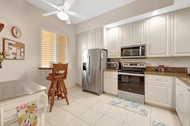 1 Harbour Isle Dr E Unit Ph2, Hutchinson Island, FL 34949 - kitchen with stainless steel appliances, a ceiling fan, white cabinets, light tile patterned floors, and recessed lighting