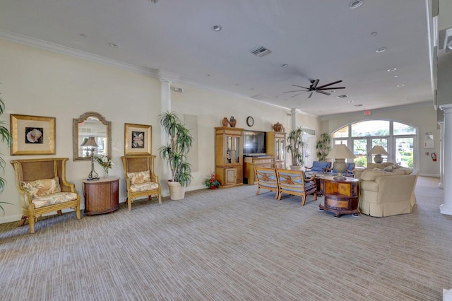 carpeted living room featuring ceiling fan, crown molding, and ornate columns