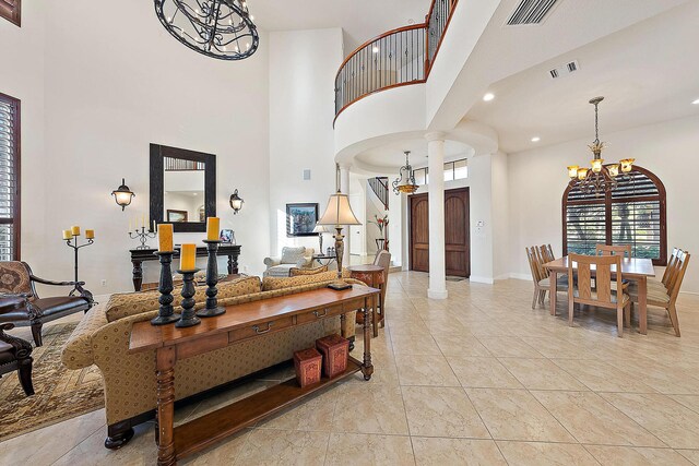 kitchen with wall chimney range hood, hanging light fixtures, stainless steel appliances, tasteful backsplash, and kitchen peninsula