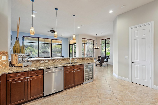 kitchen with beverage cooler, a peninsula, a sink, stainless steel dishwasher, and decorative backsplash