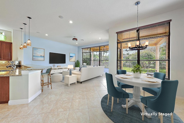 dining space with a textured ceiling, recessed lighting, light tile patterned flooring, and a notable chandelier