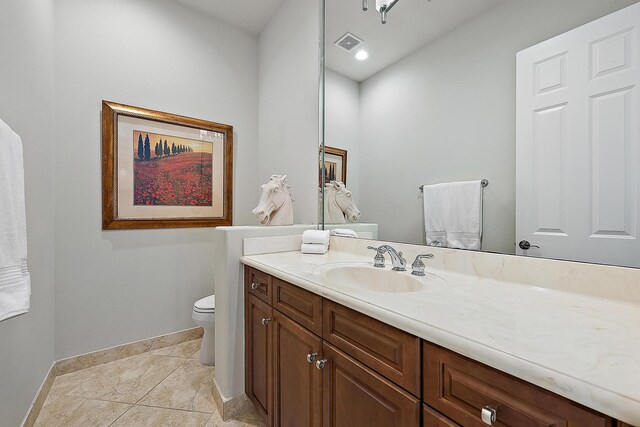 bathroom with a shower with door, vanity, tile patterned flooring, and toilet