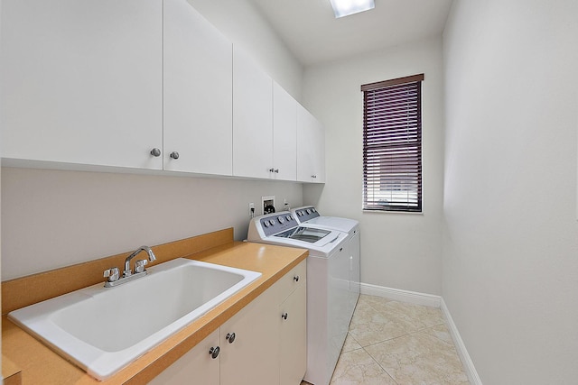 laundry area featuring cabinets, washing machine and clothes dryer, and sink