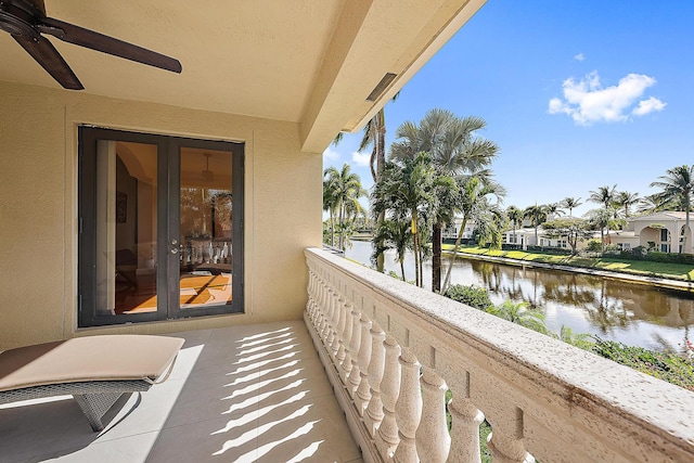 balcony featuring a water view and ceiling fan