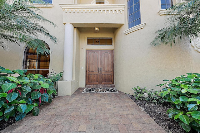 doorway to property featuring stucco siding