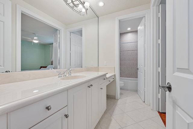 ensuite bathroom featuring connected bathroom, toilet, ceiling fan, tile patterned floors, and vanity