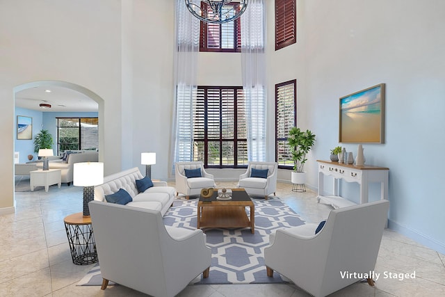 tiled living area with a healthy amount of sunlight, a high ceiling, and arched walkways