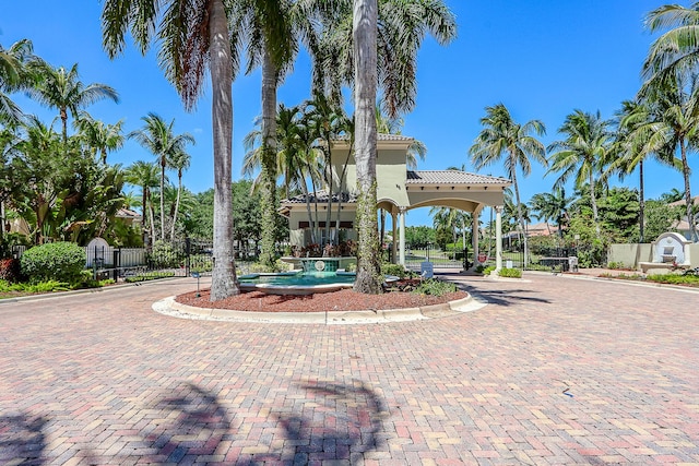 view of property's community featuring a gate, fence, and decorative driveway