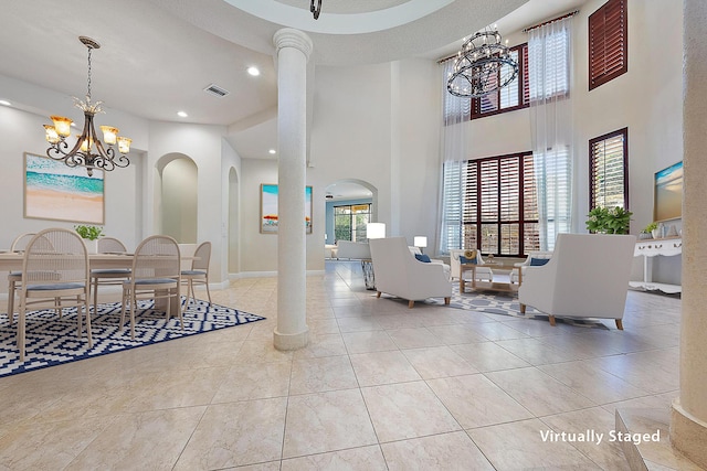 interior space featuring a notable chandelier, recessed lighting, visible vents, a towering ceiling, and baseboards