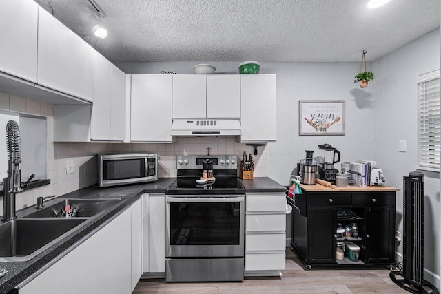 kitchen featuring stainless steel appliances, white cabinets, a textured ceiling, and sink