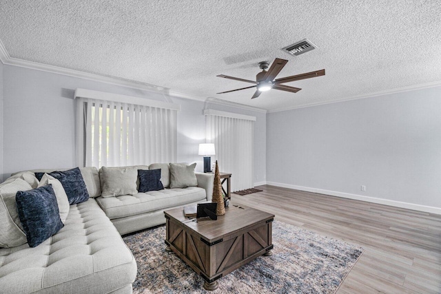 living room with a textured ceiling, ceiling fan, crown molding, and wood-type flooring