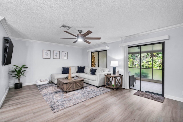 living room featuring a textured ceiling, ceiling fan, crown molding, and hardwood / wood-style floors