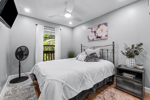 bedroom featuring ceiling fan, a textured ceiling, and wood-type flooring