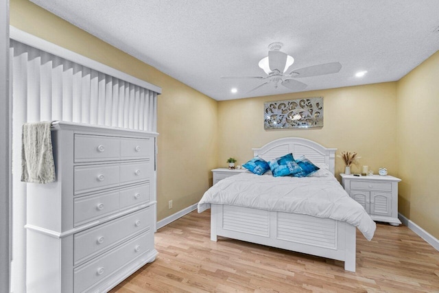 bedroom featuring a textured ceiling, ceiling fan, and light hardwood / wood-style flooring