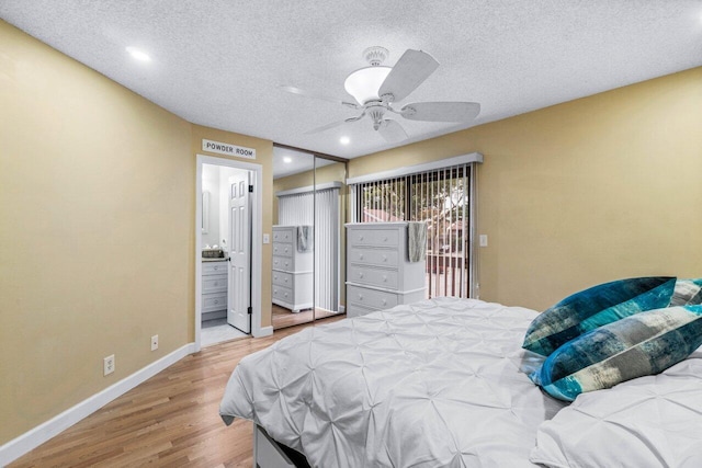 bedroom featuring a textured ceiling, ceiling fan, hardwood / wood-style flooring, a closet, and ensuite bath