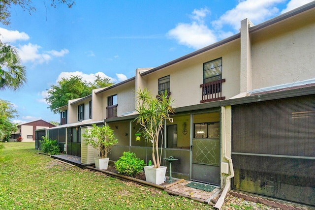 rear view of property featuring a lawn